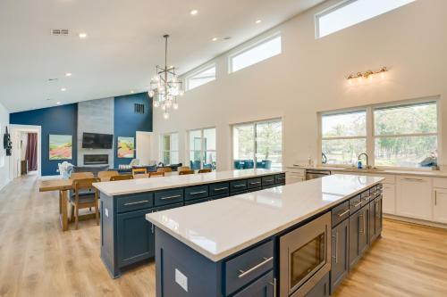 a large kitchen with blue cabinets and white countertops at Luxe Waterfront Home in Malakoff with Pool! in Malakoff