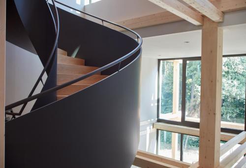 a spiral staircase in a house with windows at Hotel BERGEBLICK in Bad Tölz