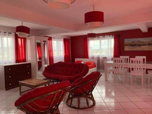 sala de estar con sofá rojo y sillas en Appartements Andrian Location en Antananarivo