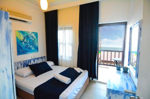 a bedroom with a bed with a view of the ocean at Side Kaktüs Boutique otel in Side