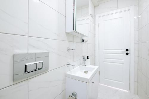 ein weißes Badezimmer mit einem Waschbecken und einem Spiegel in der Unterkunft Flat w City View Near Galata Tower in Istiklal Ave in Istanbul