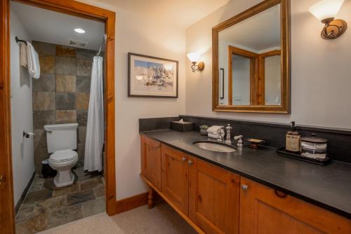 y baño con lavabo, aseo y espejo. en 3BR Spacious Benchlands Family Townhome by Harmony Whistler en Whistler