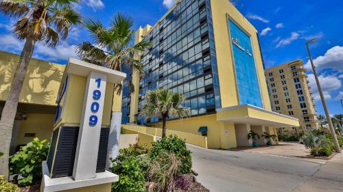 a large yellow building with a sign on it at Oceanside Inn in Daytona Beach