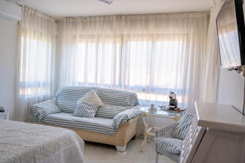 a bedroom with a couch and a chair and a window at Yedrada Alojamientos in La Adrada