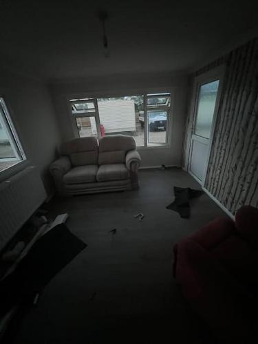 uma sala de estar com um sofá e uma janela em Mobile home for rent em Hascombe