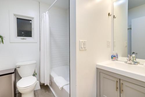a white bathroom with a toilet and a sink at South Haven Oasis - Private Hot Tub, Pool and Grill! in South Haven