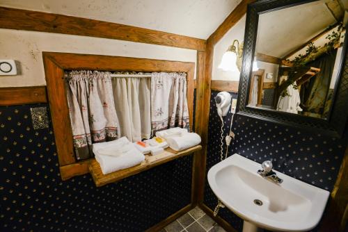 a bathroom with a sink and a mirror at Castle Wood Theme Cottages- COUPLES ONLY in Big Bear Lake