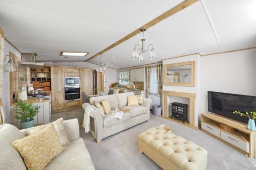 a living room with two couches and a fireplace at Stones Throw Lodge in Padstow