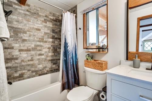 baño con aseo blanco y pared de ladrillo en Munds Park Cabin Rental 40 Mi to Sedona!, en Munds Park