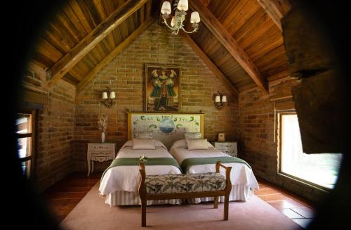sypialnia z 2 łóżkami w ceglanej ścianie w obiekcie EL TORREAL w mieście Cayambe