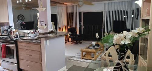 a kitchen and living room with a counter with flowers at Ocean, Beachfront OASIS in Waianae