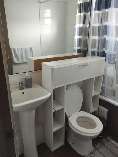 a bathroom with a sink and a toilet and a mirror at Acogedora y Central Casa in La Serena