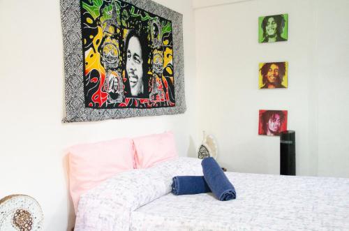 a bedroom with a bed and some pictures on the wall at Colibri Ecolodge 3 minutes walk to beach and town in Puerto Viejo