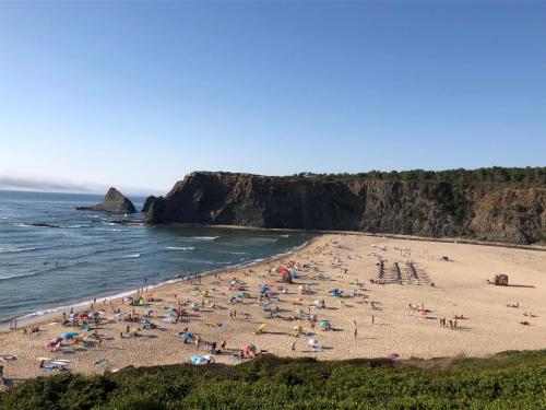 a group of people on a beach near the ocean at Heu’s Monte in Odemira