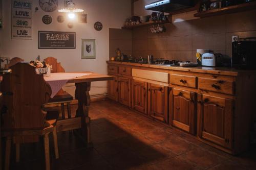 una cocina con armarios de madera y una mesa. en Cabana Bendis en Rîşnov