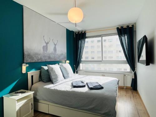 une chambre avec un lit aux murs bleus et une fenêtre dans l'établissement 2 ch, climatisé, parking, localisation premium, à Lyon