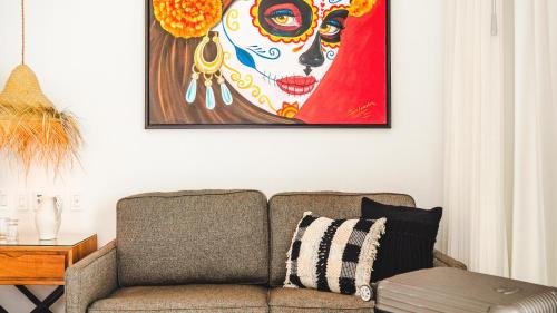 a living room with a couch and a painting of a sugar skull at La Puesta Sayulita in Sayulita