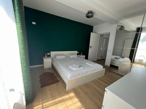 ein Schlafzimmer mit einem Bett und einer grünen Wand in der Unterkunft Sky Residence Airport or Therme Spa no 10 in Otopeni