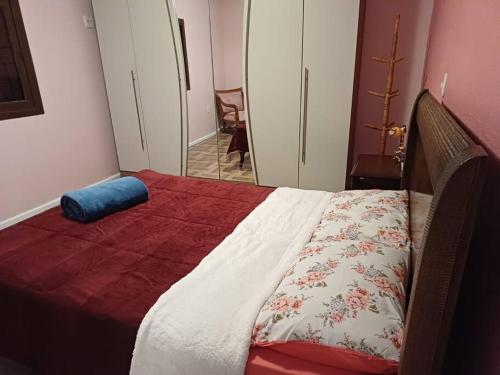 a bedroom with a bed with a red and white blanket at Casa na Serra Gaucha Canela in Canela