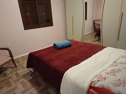 Un dormitorio con una cama con una almohada azul. en Casa na Serra Gaucha Canela en Canela
