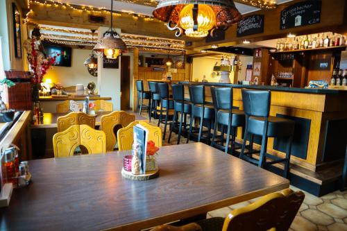 un restaurante con mesa de madera y sillas y un bar en Gasthof Sonnental en Winterberg