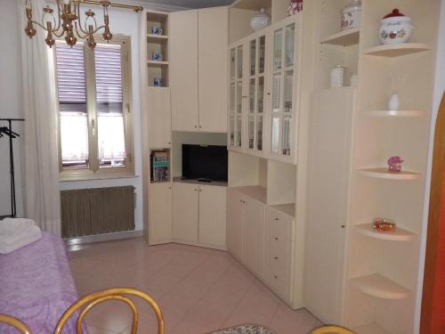 a living room with white cabinets and a tv at Geena's Home in La Spezia