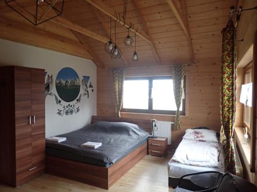 1 dormitorio con 2 camas en una cabaña de madera en Agroturystyka Góra Fiedora, en Pieniążkowice