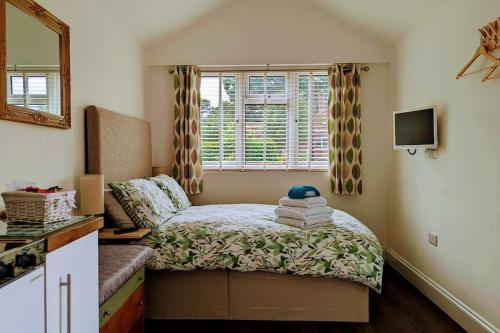Habitación pequeña con cama y ventana en Oak Tree View - relax, reconnect, explore or work en East Harling