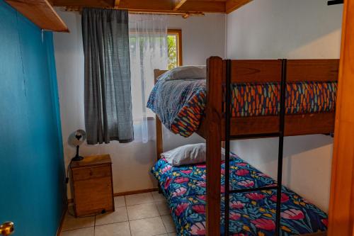 a bedroom with two bunk beds and a window at Cabañas Hostel Aquario Papudo in Papudo