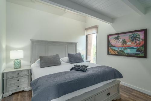 a white bedroom with a bed and a window at 401 Maalaea Banyans in Wailuku