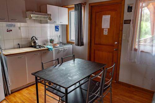 a small kitchen with a table and chairs in it at Departamentos Aquario Papudo in Papudo