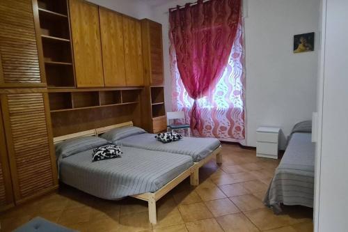 een slaapkamer met 2 bedden en een raam bij Casa Baffo in Piombino