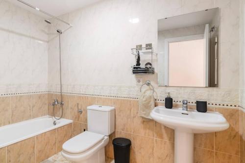 y baño con aseo, lavabo y espejo. en Grand Apartament Lloret, en Lloret de Mar