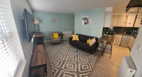 a living room with a couch and a kitchen at 2 bed Home From Home Apartments in London