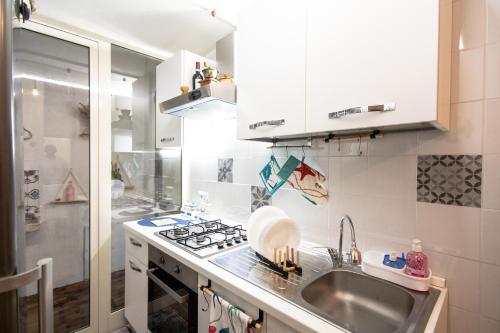 a small kitchen with a sink and a stove at casa vacanze Casa del Mare in Acitrezza