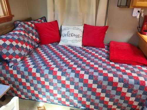 Una cama con almohadas rojas encima. en Caravan Across The Street From The Beach, en Blaine