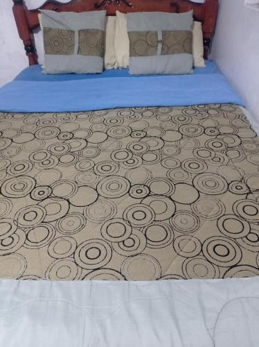 a bed with a comforter with a swirl design on it at ESCOCIE-VA 1 in Quito