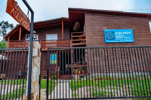 a wooden house with a sign in front of it at Departamentos Aquario Papudo in Papudo
