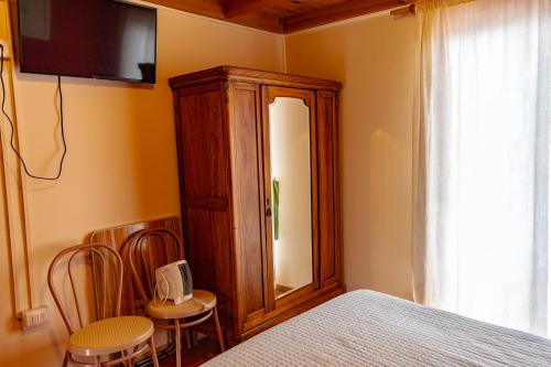 a bedroom with a bed and a mirror and chairs at Departamentos Aquario Papudo in Papudo