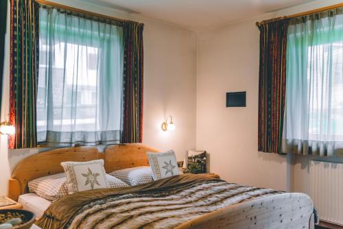 - une chambre avec un lit et 2 fenêtres dans l'établissement Garni Hotel Belalp, à Santa Cristina Valgardena