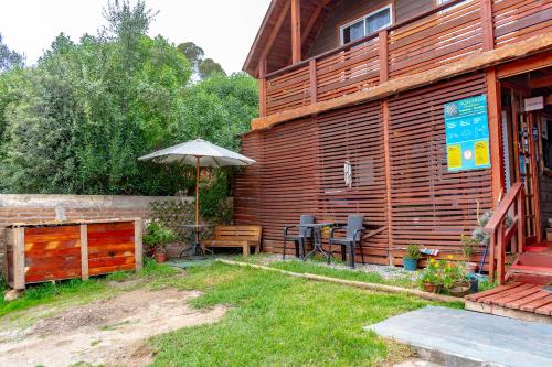 a patio with an umbrella next to a house at Departamentos Aquario Papudo in Papudo