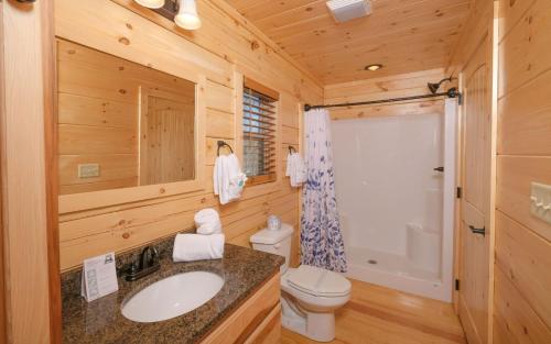 a log cabin bathroom with a sink and a toilet at My Morning Gatlinburg in Gatlinburg