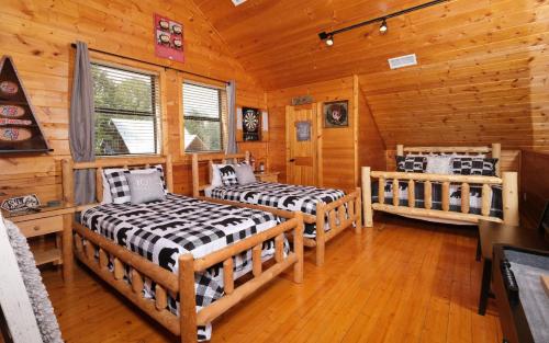 a bedroom with two beds in a log cabin at Heavenly Haze Hideaway in Sevierville