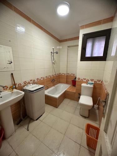 a bathroom with a tub and a toilet and a sink at Apartment Sedi Beshr in Alexandria