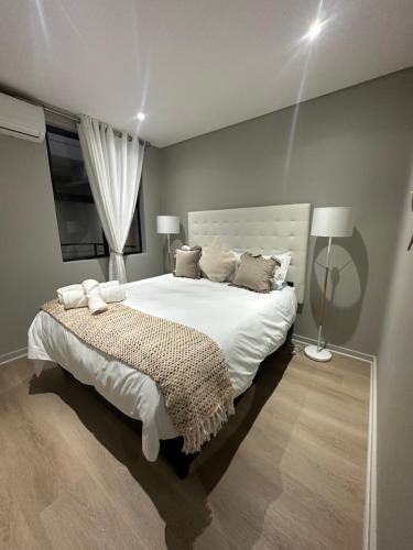 sypialnia z dużym białym łóżkiem i oknem w obiekcie TheRestInn @ 2Six2 Florida w mieście Durban