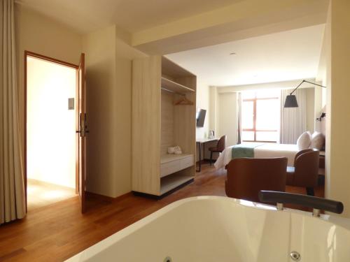 Talavera的住宿－Muña Hotel，带浴缸的浴室和1间带1张床的卧室