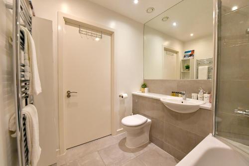 a bathroom with a toilet and a sink and a shower at Bright Amelia Lodge - 2 bed 1 bath with WIFI and Netflix in the heart of London in London