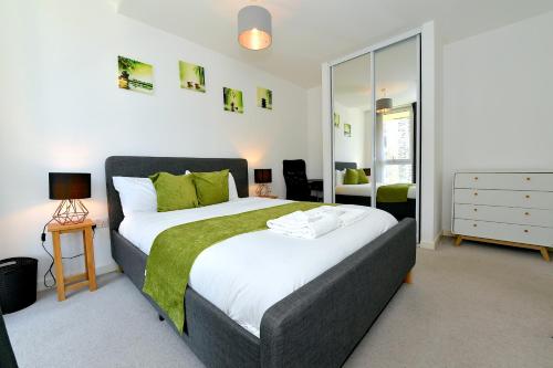 a bedroom with a large bed with a green blanket at Bright Amelia Lodge - 2 bed 1 bath with WIFI and Netflix in the heart of London in London