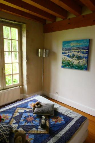 a bedroom with a bed with a stuffed animal on it at Maison en bord de Loire Le repaire du chat in Beaugency