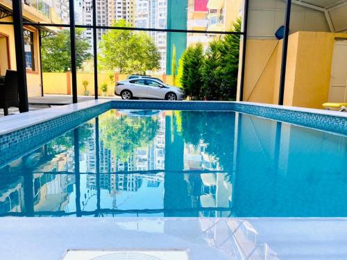 a swimming pool with a car parked next to a building at Hotel Royal Palace in Batumi